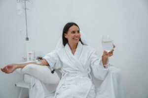 beautiful-woman-white-bathrobe-drink-water-during-medical-procedure-beauty-clinic
